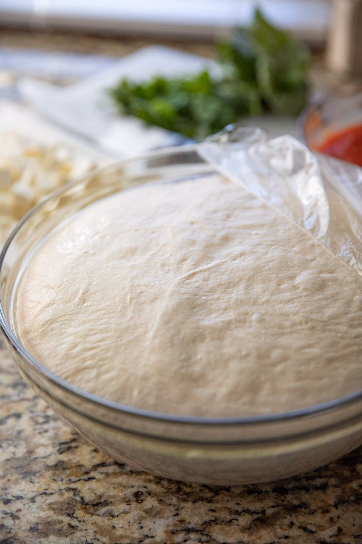 Do you need to bake pizza dough before adding toppings?