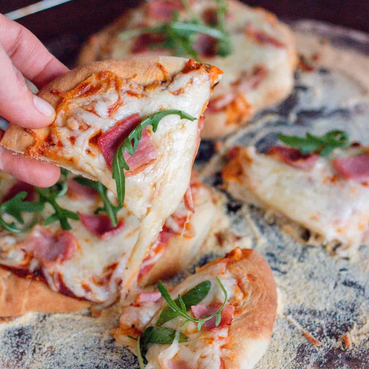 How long should you bake pizza dough before adding toppings?