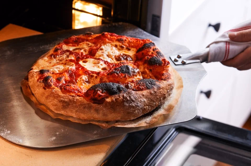 How do you get a pizza oven hot?
